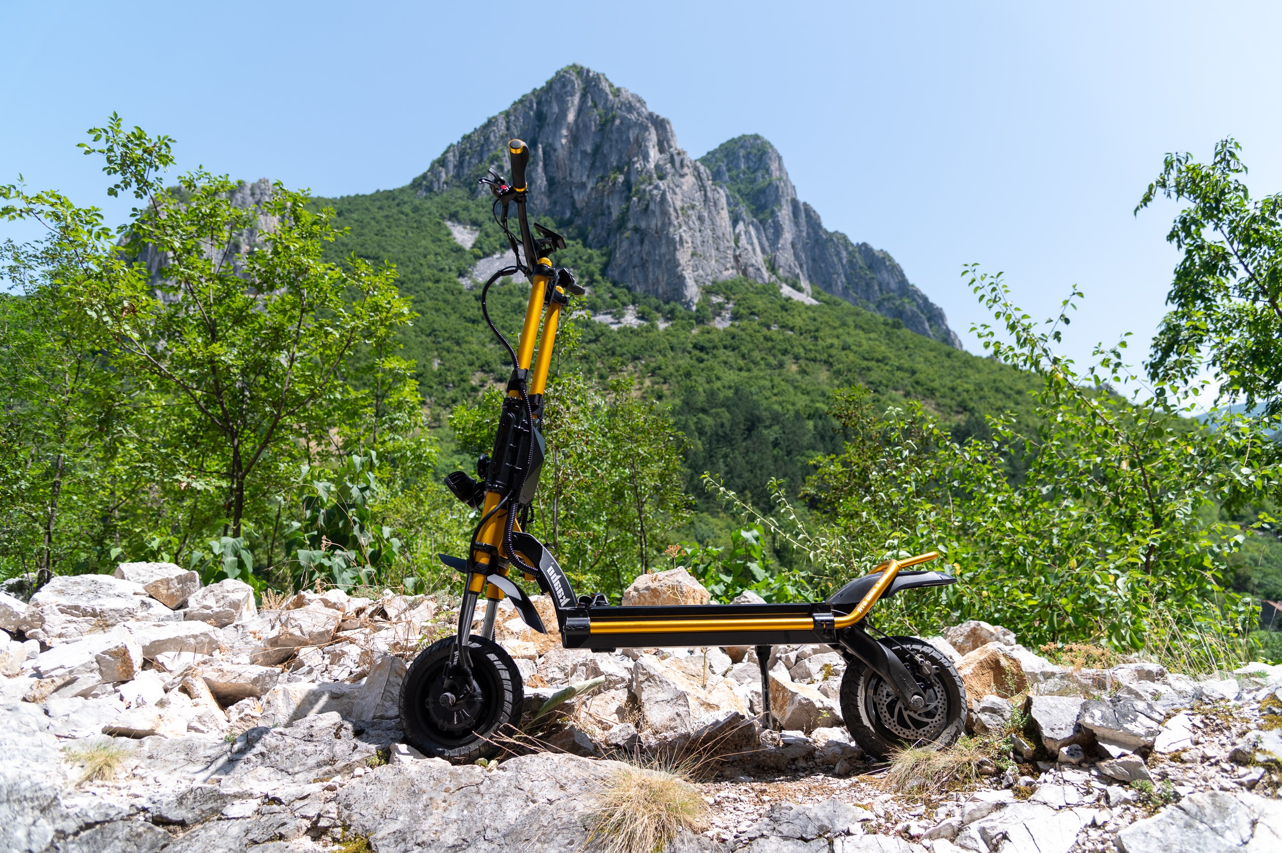 Yellow electric scooter on rocky mountain trail