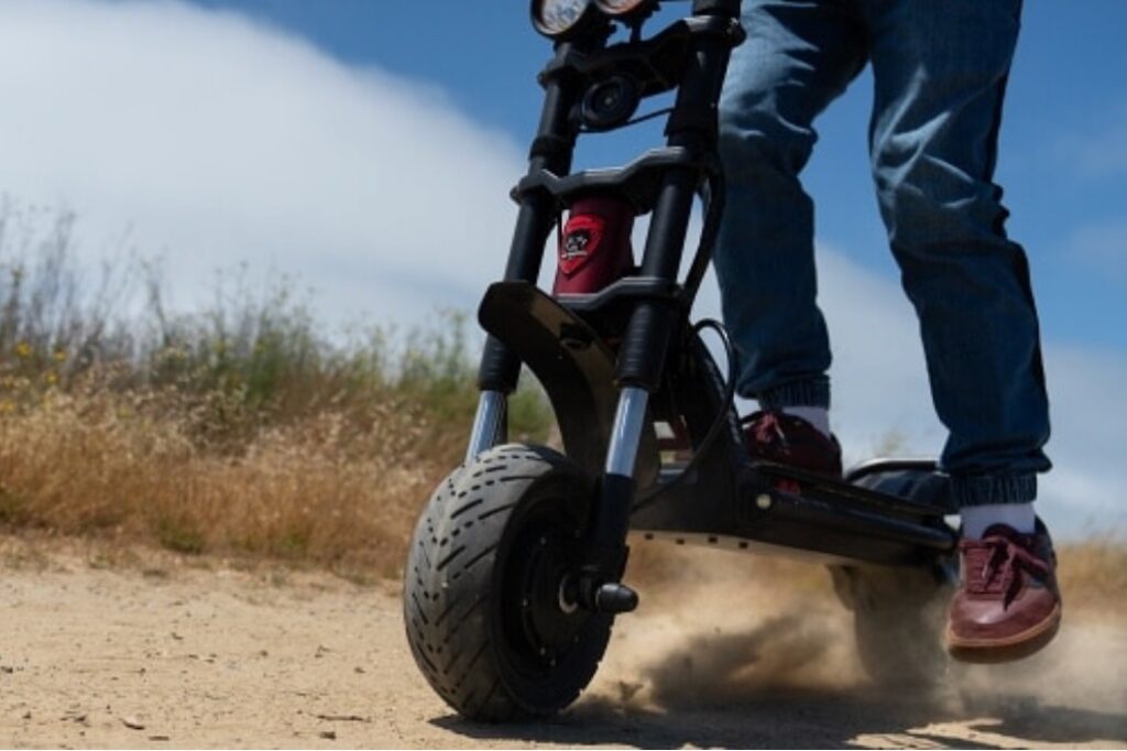Person riding electric scooter on dirt trail