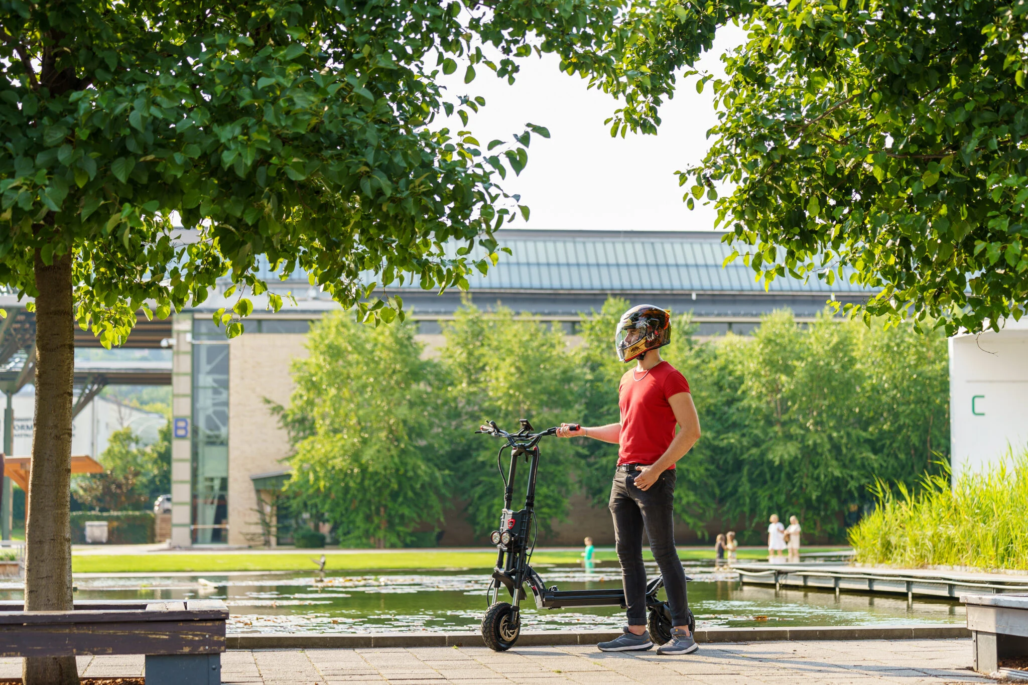 Person in helmet with electric scooter at park