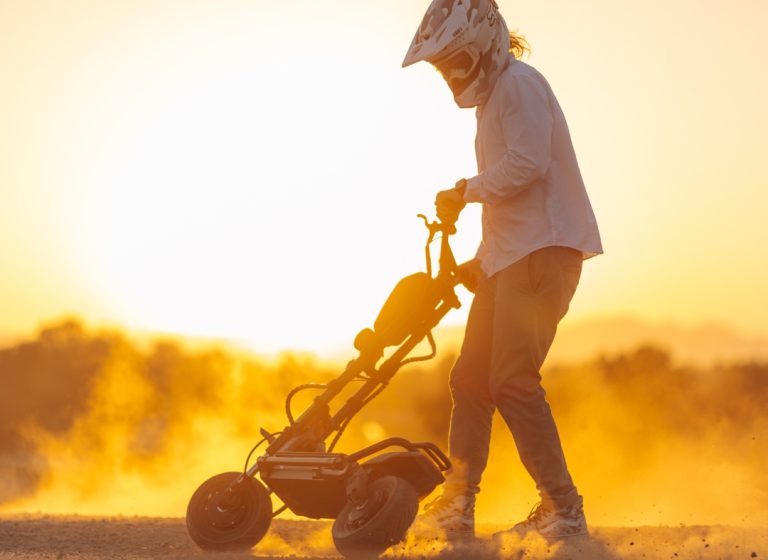 Rider on electric off-road scooter at sunset